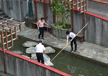 地元の方から竿を借り、川底のゴミを回収する